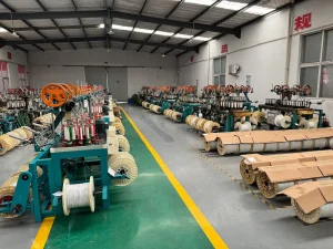 Organized inventory of semi-finished white cable spools on the factory floor, ready for processing.
