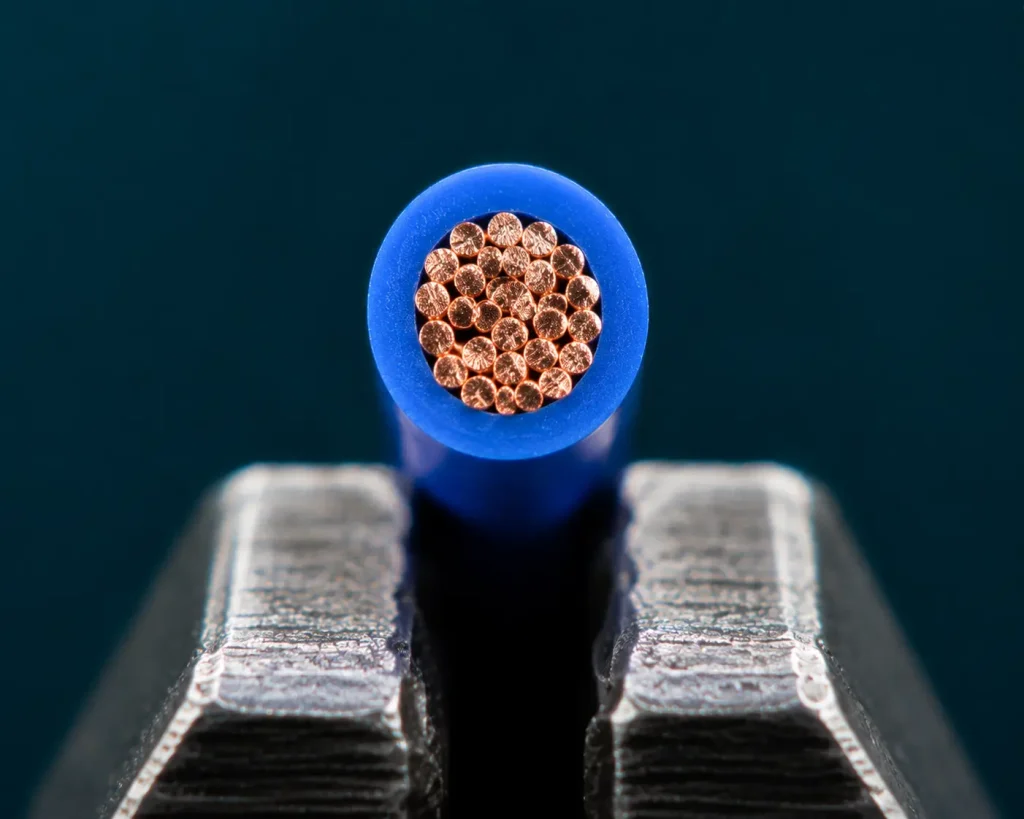 Macro cut end of UL AWM 1571 24 AWG PVC signal wire showing thin insulation wall and stranded copper conductor