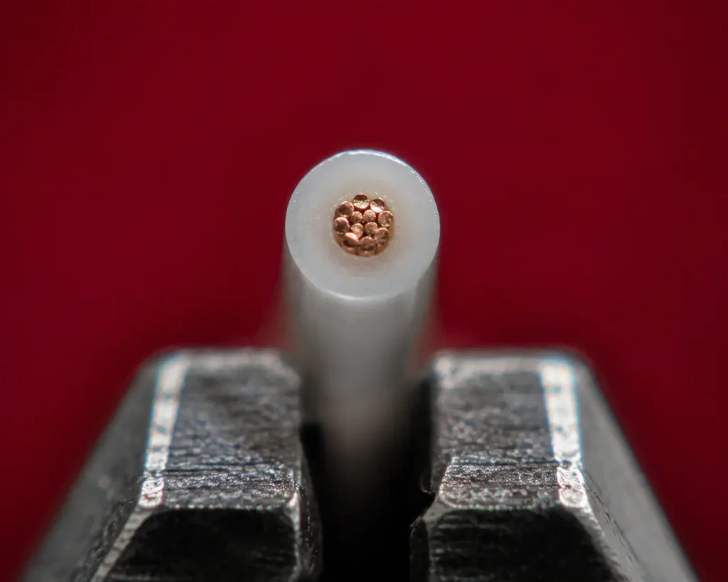 acro cut end of UL AWM 1571 30 AWG ultra-fine wire showing thin PVC insulation wall and tiny copper conductor